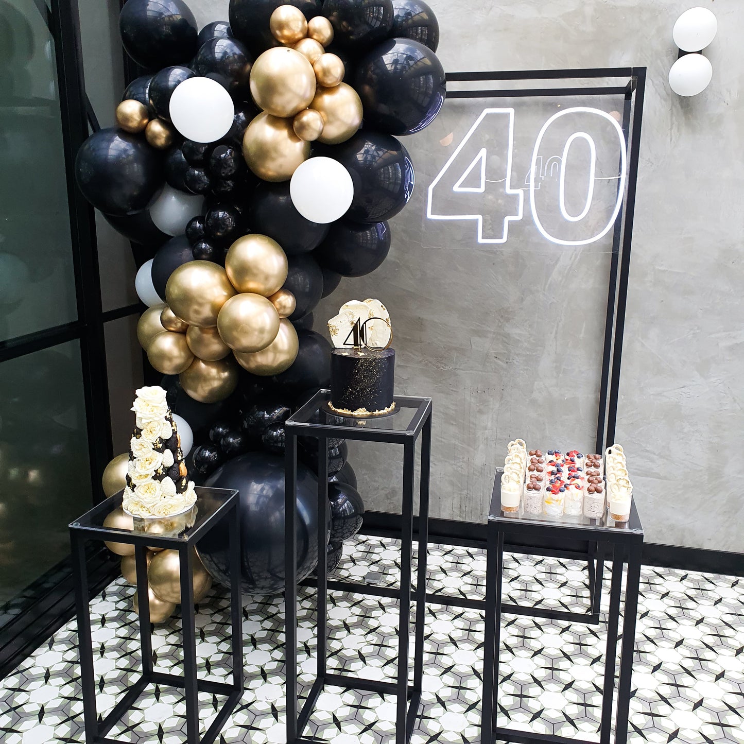 Black steel frame with matching set of 3 black steel cake plinths for birthday party, hens party or engagement. Light up neon sign and custom dessert displayed
