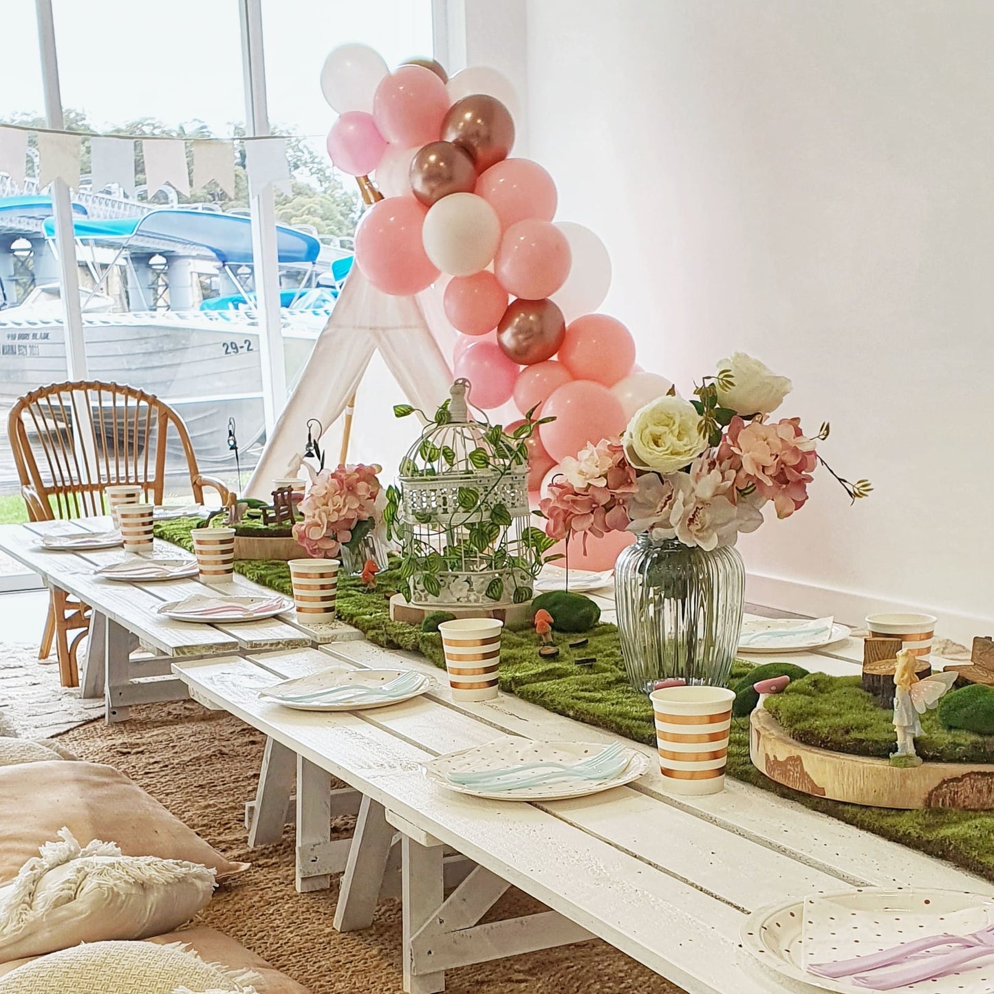 Child size trestle tables and picnic styling for a Fairy themed birthday. Teepee and fairy cages, fairy garden party decor and table runners, rugs and cushions