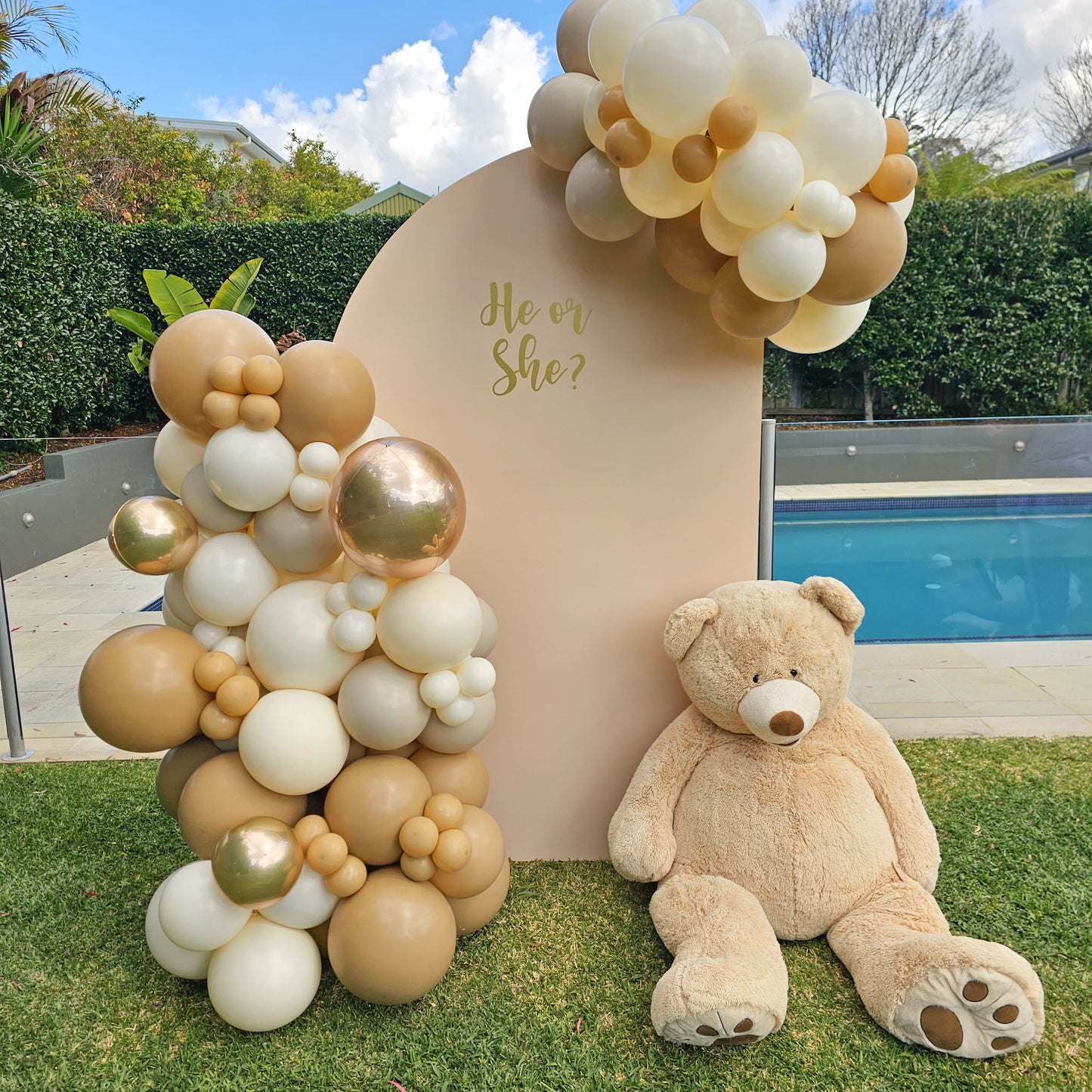 Lifesize teddy bear with organic balloon garland for a gender reveal party