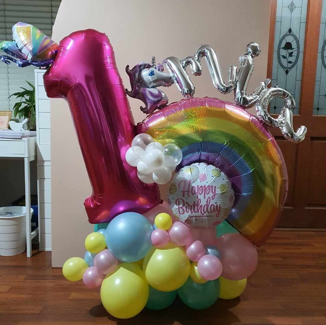 Rainbow baby 1st birthday balloon stack. With Jumbo Number, Supershape foil balloon rainbow and child's name added. Pastel rainbow colours with a happy birthday foil balloon.