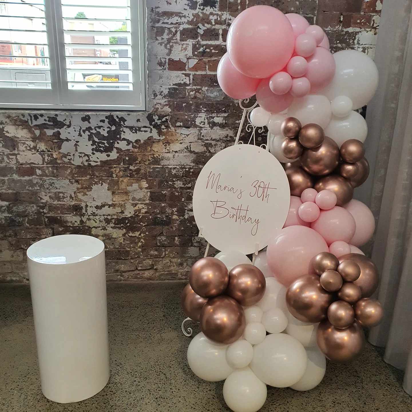 White ornate easel, acrylic sign, balloon garland and plinth for this birthday celebration. Great for smaller spaces and decorations on a budget