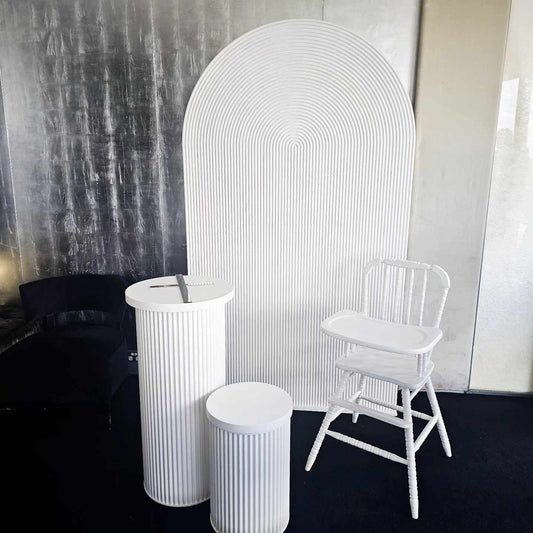 White ripple arch backdrop with white ripple plinths and vintage high chair in white for hire in sydney