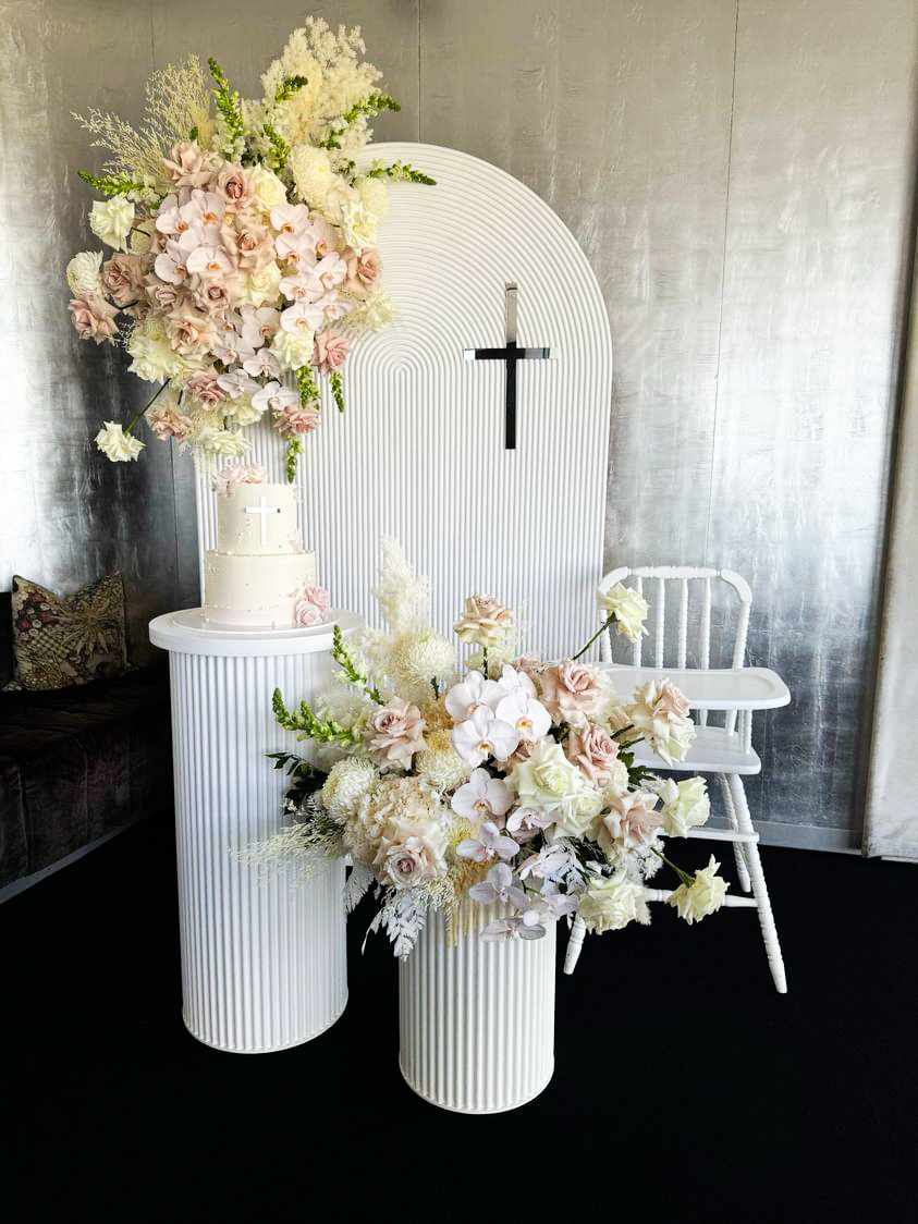 Vintage White high chair paired with our Ripple backdrop package. Ripple Arch backdrop, 2 ripple plinths and fresh florals.