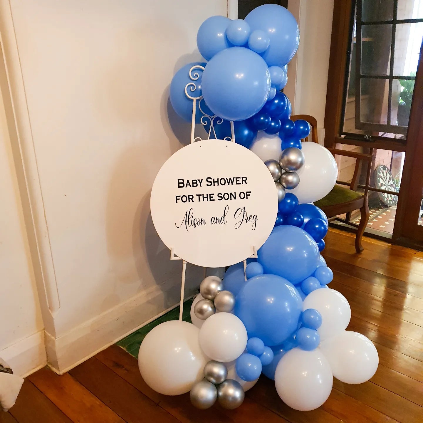 White ornate easel, acrylic sign, balloon garland and plinth for this intimate baby shower decoration. Great for smaller spaces and decor on a budget