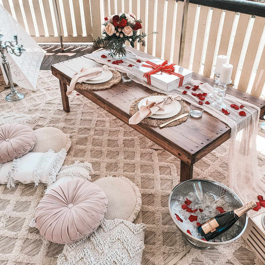 Romantic couples picnic with fresh roses, rose petals grazing box, chilled champagne, candles and styling for a sweet proposal idea