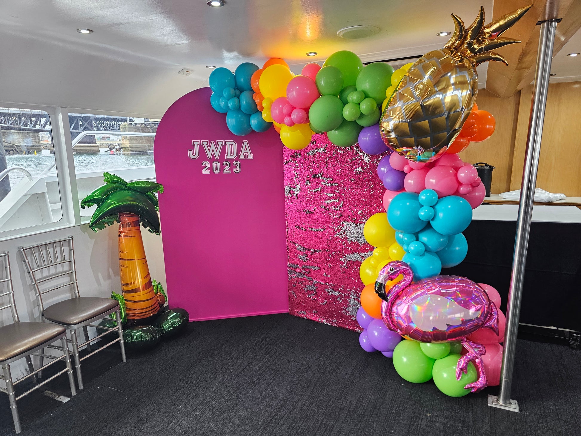 Hot pink medium arch backdrop with our pink and silver sequin wall, large organic balloon garland decoration with foil balloons added for a birthday, end of year celebration or graduation party.