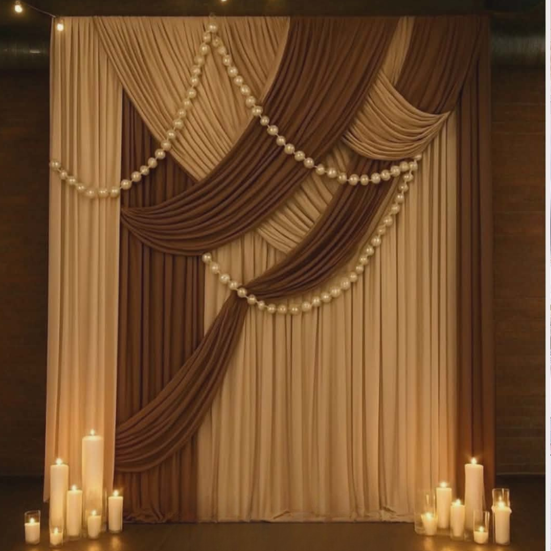 Decorative two toned draped curtain with pearls and candles on a dark background